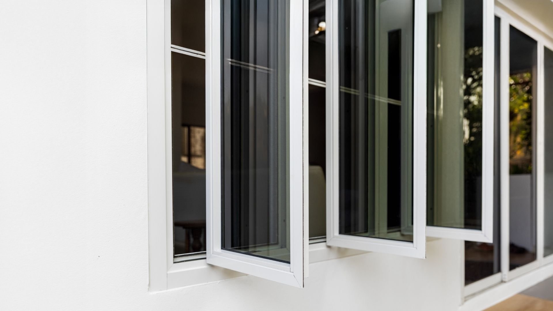 White windows partially open showing glass panes and exterior view