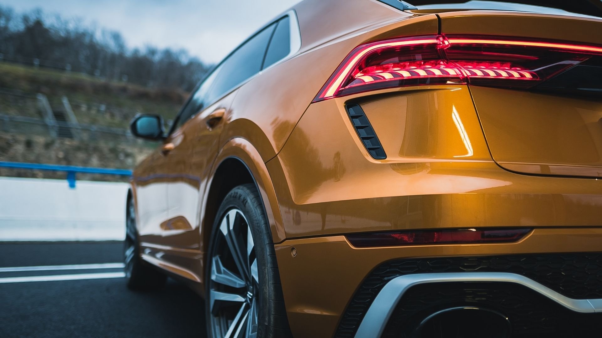 Golden luxury SUV with sleek design and glowing red taillights